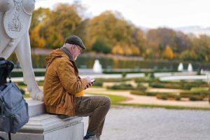 a man sitting on a bench looking at his phone — Abogado Chicago workers comp lawyer near me