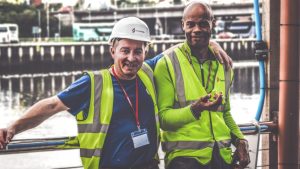 selective focus photography of two men standing side by side wearing green reflective vests — Illinois workers compensation attorney Chicago