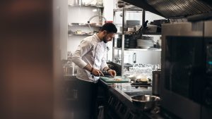 man in white dress shirt holding white ceramic plate — abogado de compensación laboral en Chicago IL